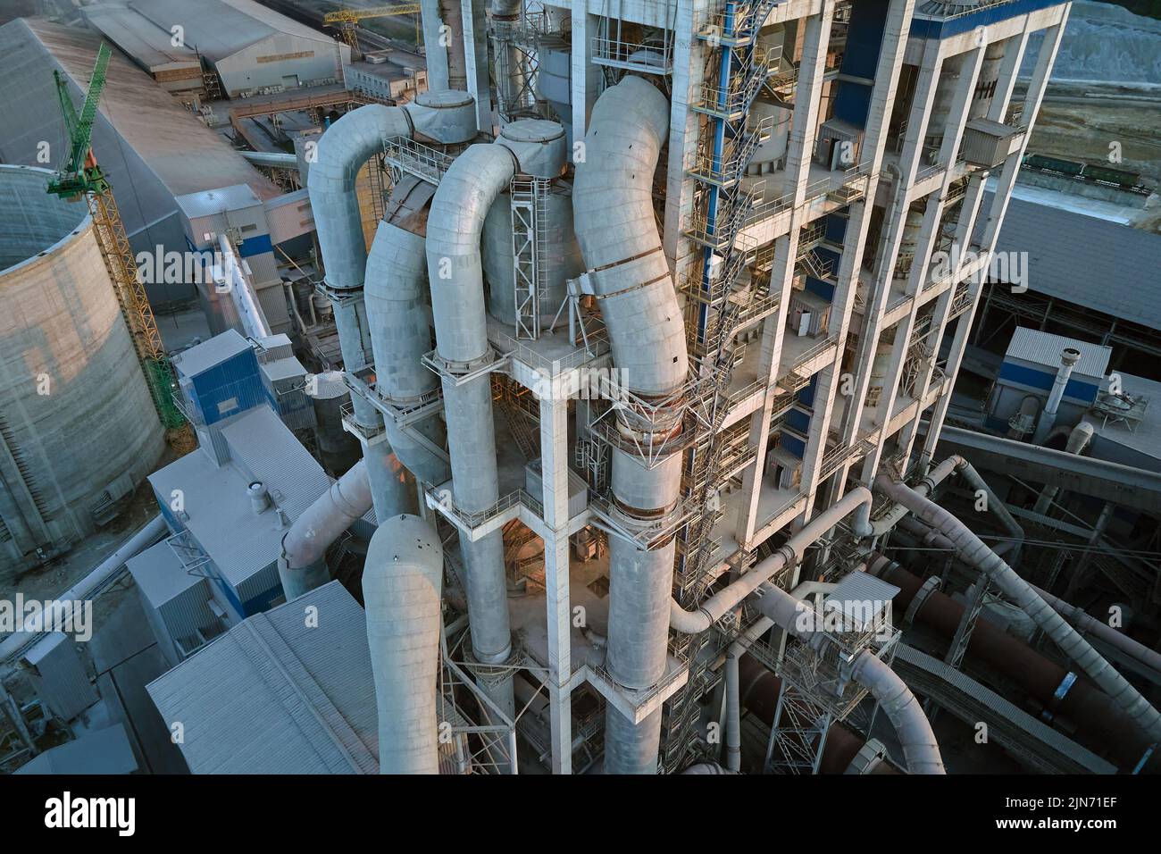 Vue aérienne de l'usine de ciment avec une structure en béton élevée et une grue à tour sur le site de production industriel. Fabrication et industrie mondiale Banque D'Images