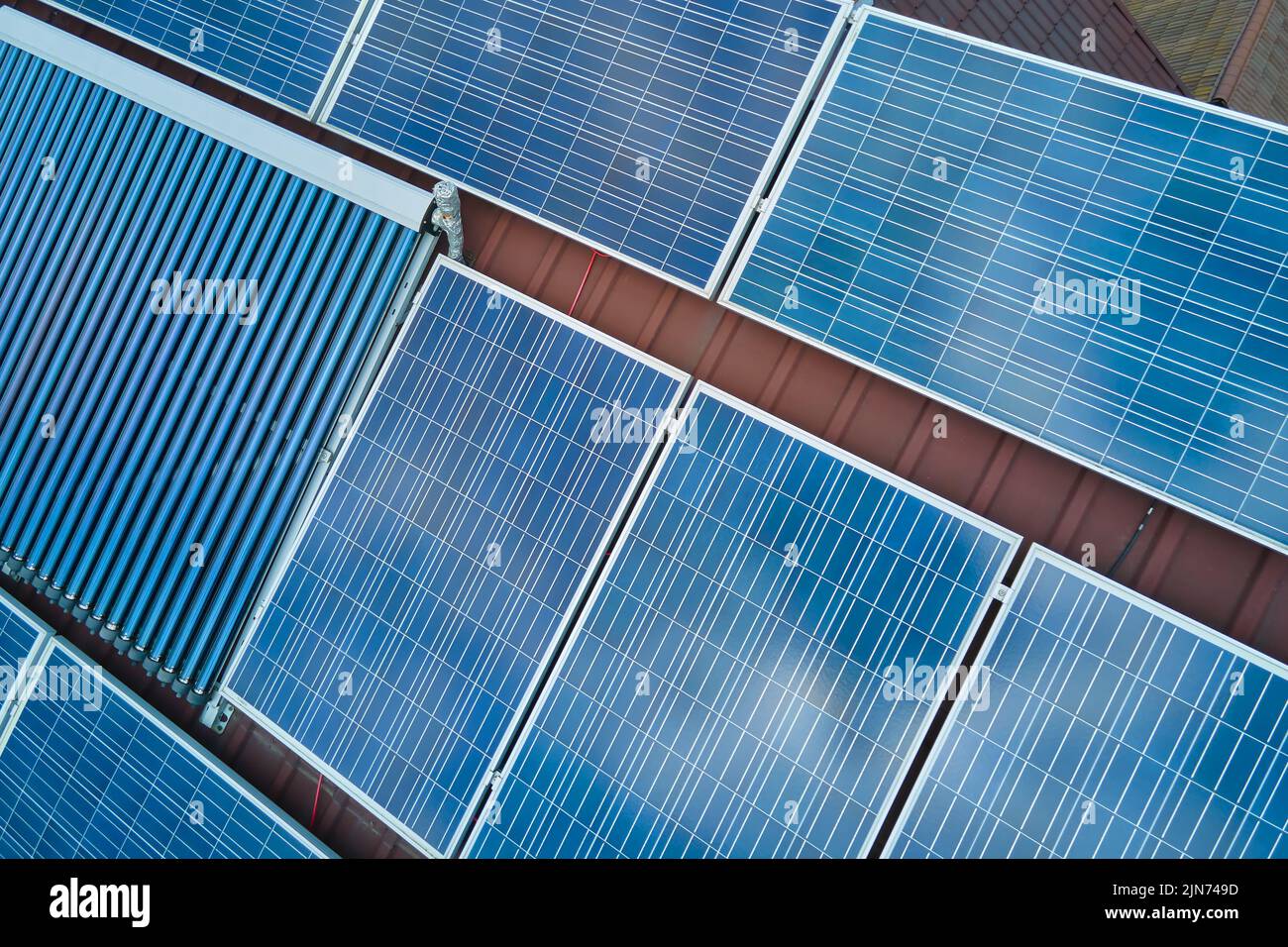 Panneaux photovoltaïques et capteurs solaires d'air à vide pour le chauffage de l'eau et la production d'électricité propre montés sur le toit de la maison. Production de Banque D'Images