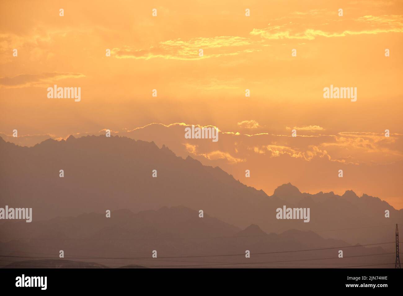 Paysage de coucher de soleil avec des sommets de montagne sombres dans le désert égyptien Banque D'Images