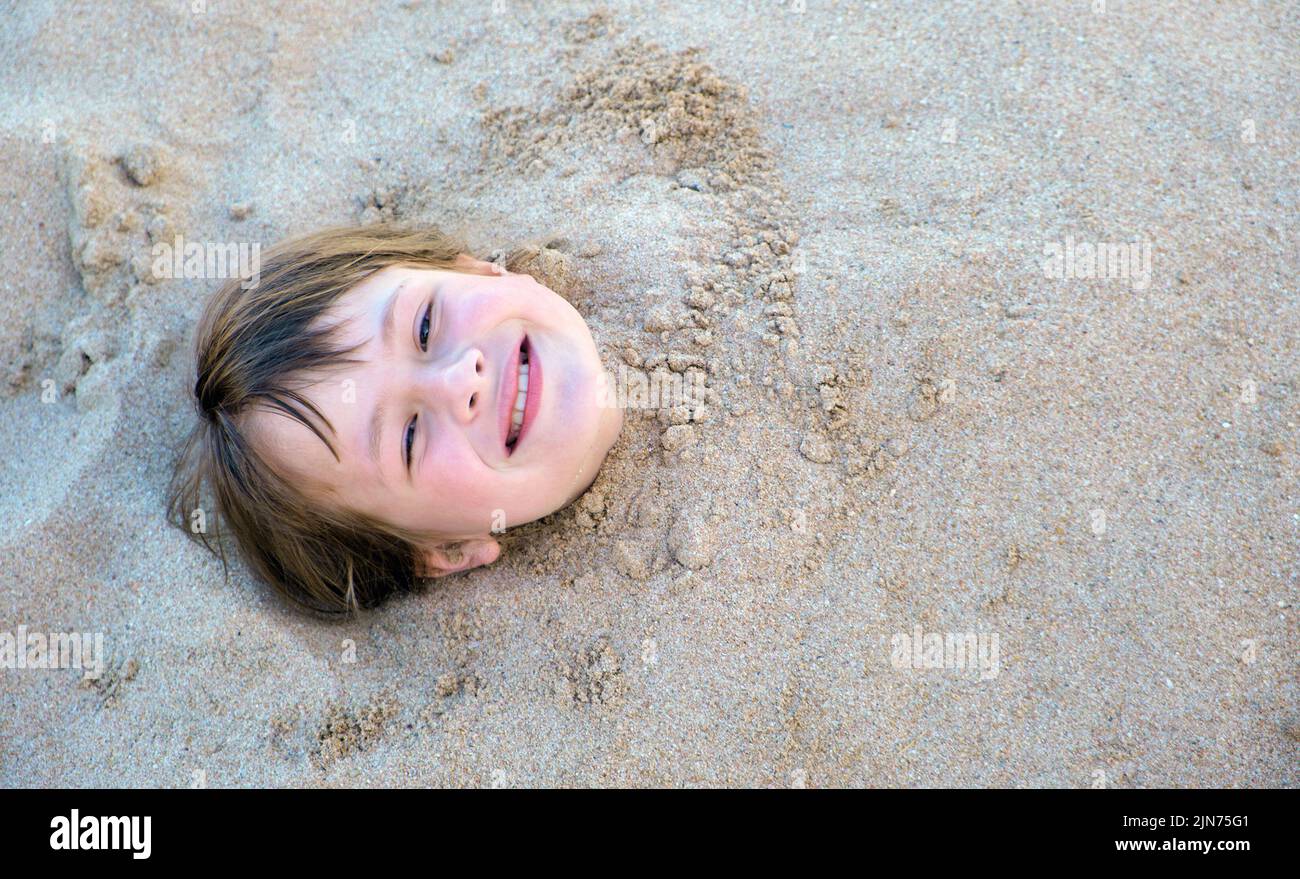 Jeune fille souriante couchée avec du sable blanc sur la plage tropicale sur fond bleu ciel et eau de l'océan Banque D'Images