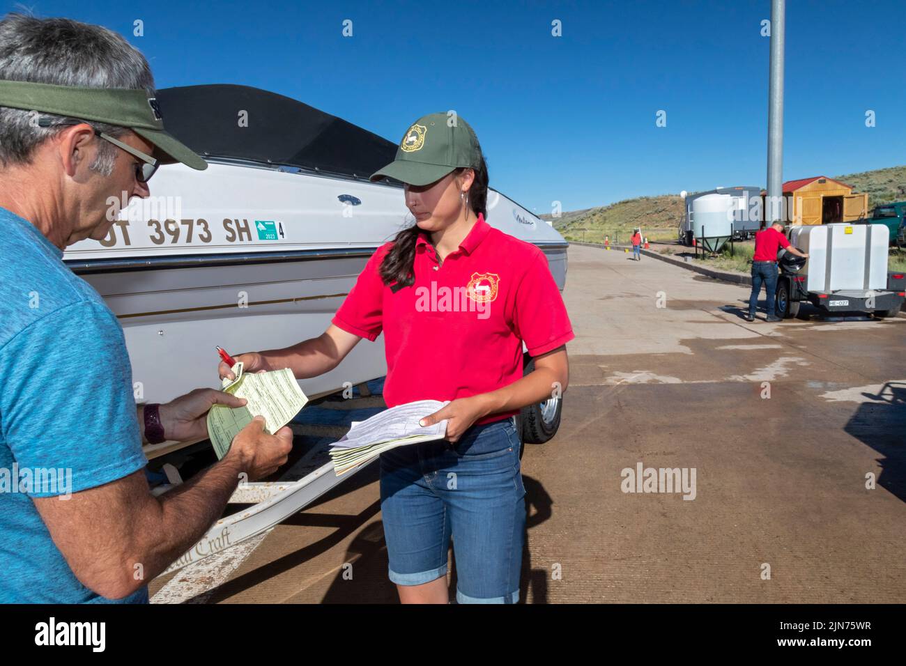 Evanston, Wyoming - un employé du Wyoming Game & Fish Department remet un reçu au propriétaire du bateau après avoir inspecté et décontaminé l'embarcation Banque D'Images