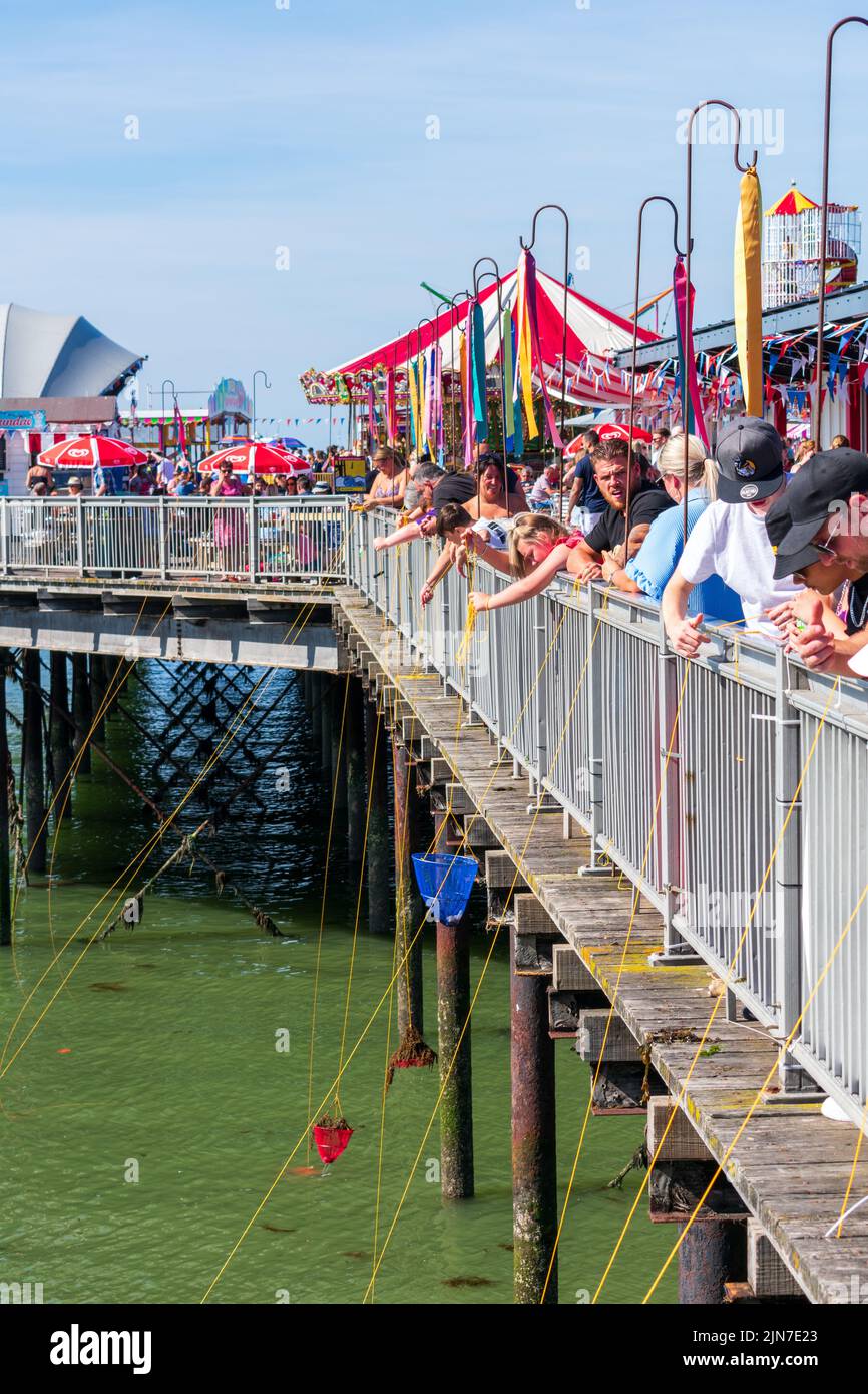 Baie de Herne, Kent, Royaume-Uni - 7 août 2022 : ciel bleu clair et températures chaudes avec des troupeaux de personnes qui essaient sur la côte pendant un week-end d'août. Banque D'Images