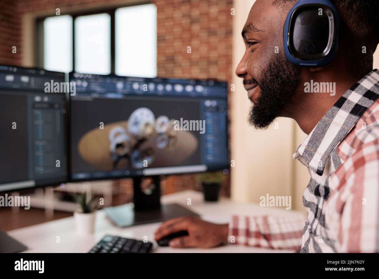 Un ingénieur CAO effectue un prototypage de machines sur pc, porte des écouteurs et crée un modèle d'engrenages industriels sur des logiciels techniques. Développement de graphiques de moteur de machine et fabrication 3D. Banque D'Images