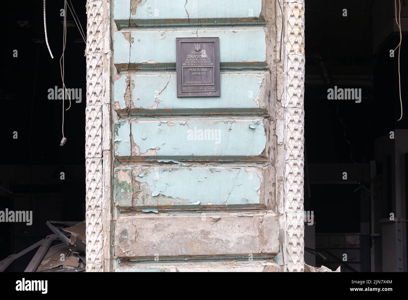 Monument architectural endommagé de la ville de Kharkiv en raison des bombardements russes. Une plaque commémorative sur la valeur architecturale de l'édifice est visible sur le mur de l'édifice. L'inscription est un monument de l'architecture et de l'urbanisme d'importance locale. Magasinez en 1894. Banque D'Images