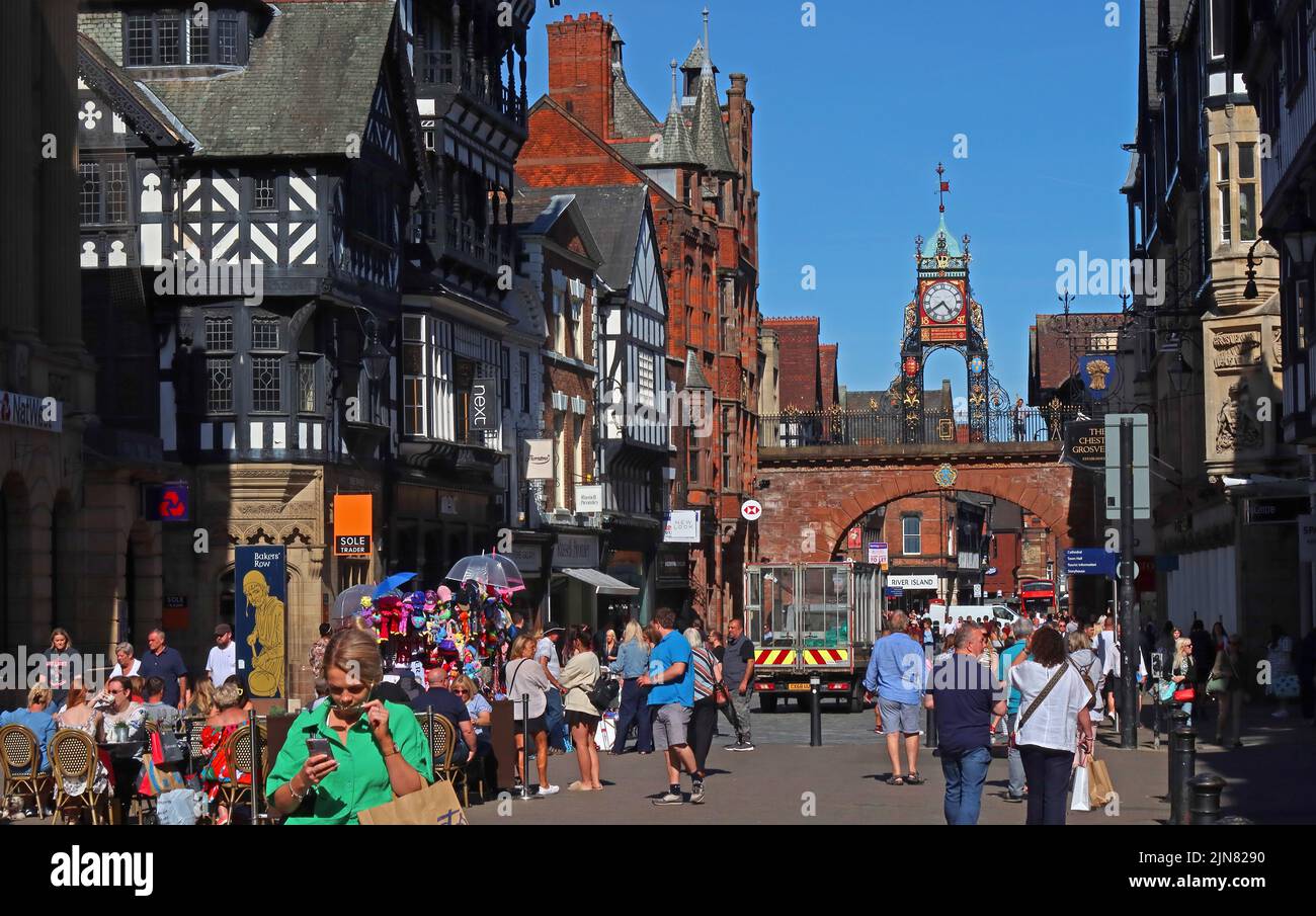 Eastgate, les acheteurs avec la célèbre horloge de la tourelle Eastgate, au-dessus de l'Eastgate des murs anciens de Chester, Cheshire, Angleterre, Royaume-Uni, CH1 1LE Banque D'Images