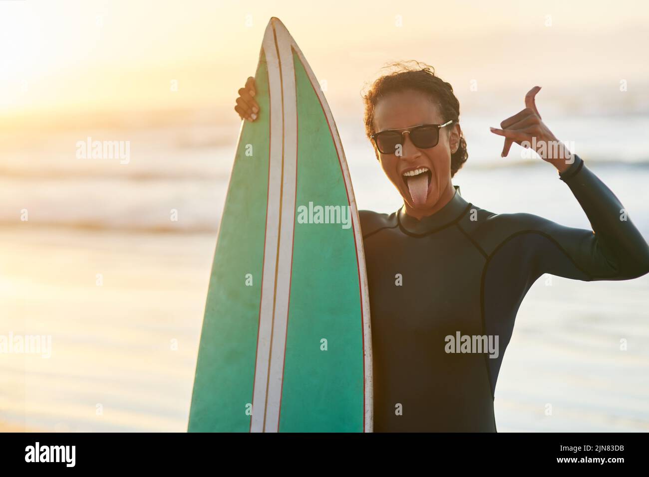 Les jours passés à la plage sont toujours les meilleurs. Portrait d'une belle jeune femme surfeuse posant avec sa planche de surf à la plage. Banque D'Images