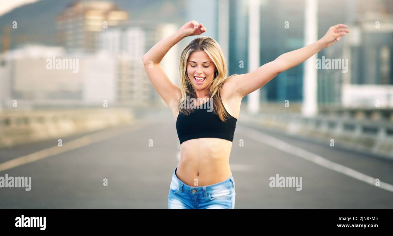 Dansant tous mes soucis loin. Une jeune femme attrayante exécutant une routine de danse de rue pendant la journée en plein air. Banque D'Images