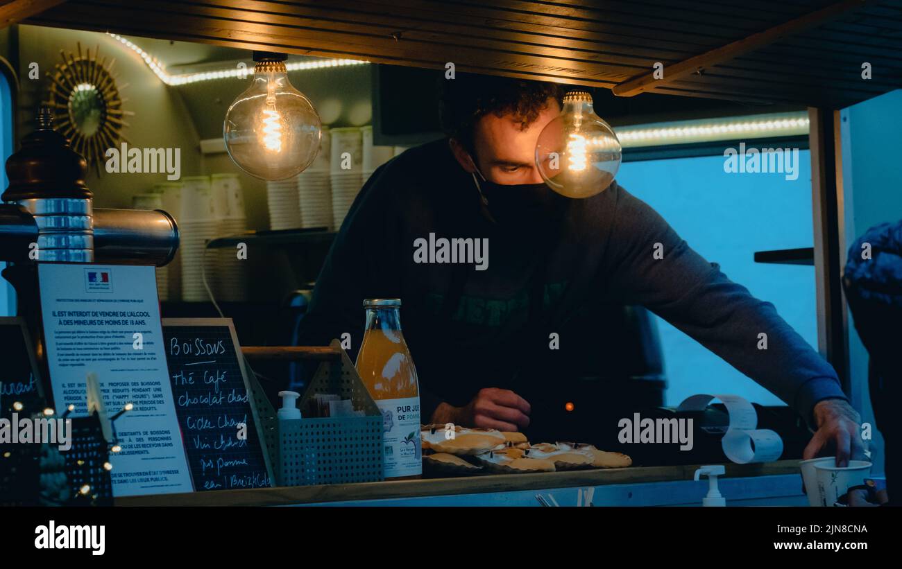 Un homme qui vend des boissons de sa caravane pendant les vacances de Noël en France Banque D'Images