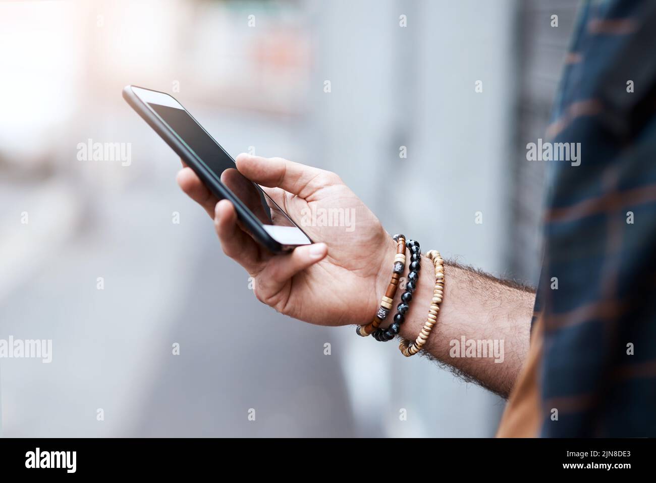 Votre meilleur compagnon de voyage dans la ville. Un homme méconnaissable utilisant son téléphone portable dans la ville. Banque D'Images