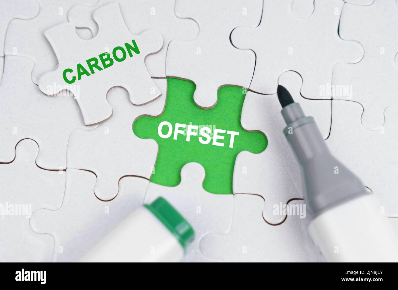 Concept d'écologie. Les puzzles blanches se trouvent sur un fond vert, à la place d'un puzzle ouvert il est écrit - carbone offset Banque D'Images