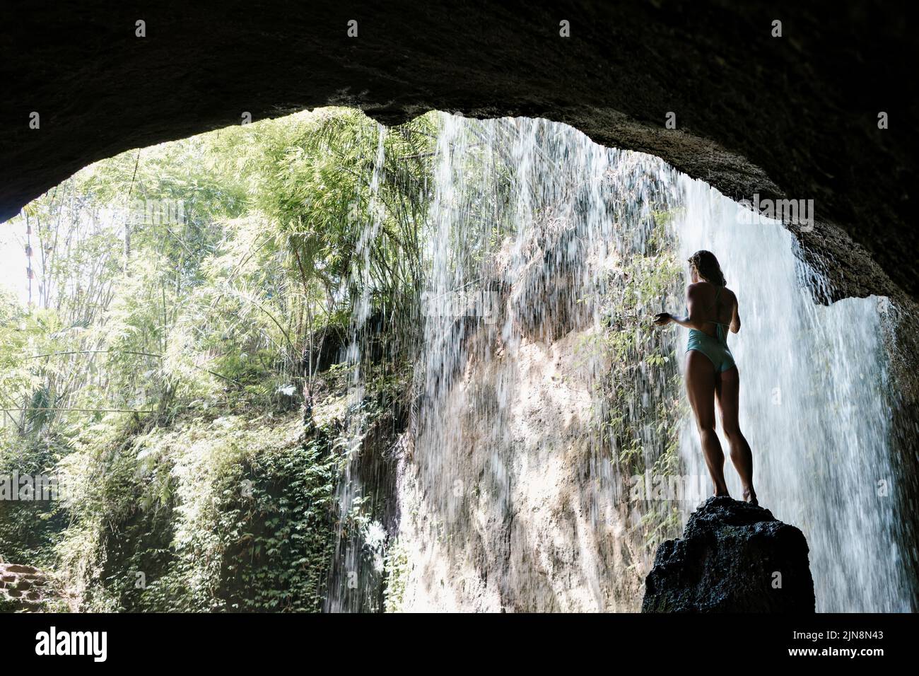 Femme En Bikini Assis Sur La Roche Sous L Eau Tombant De Suwat Cascade Dans La Jungle Tropicale