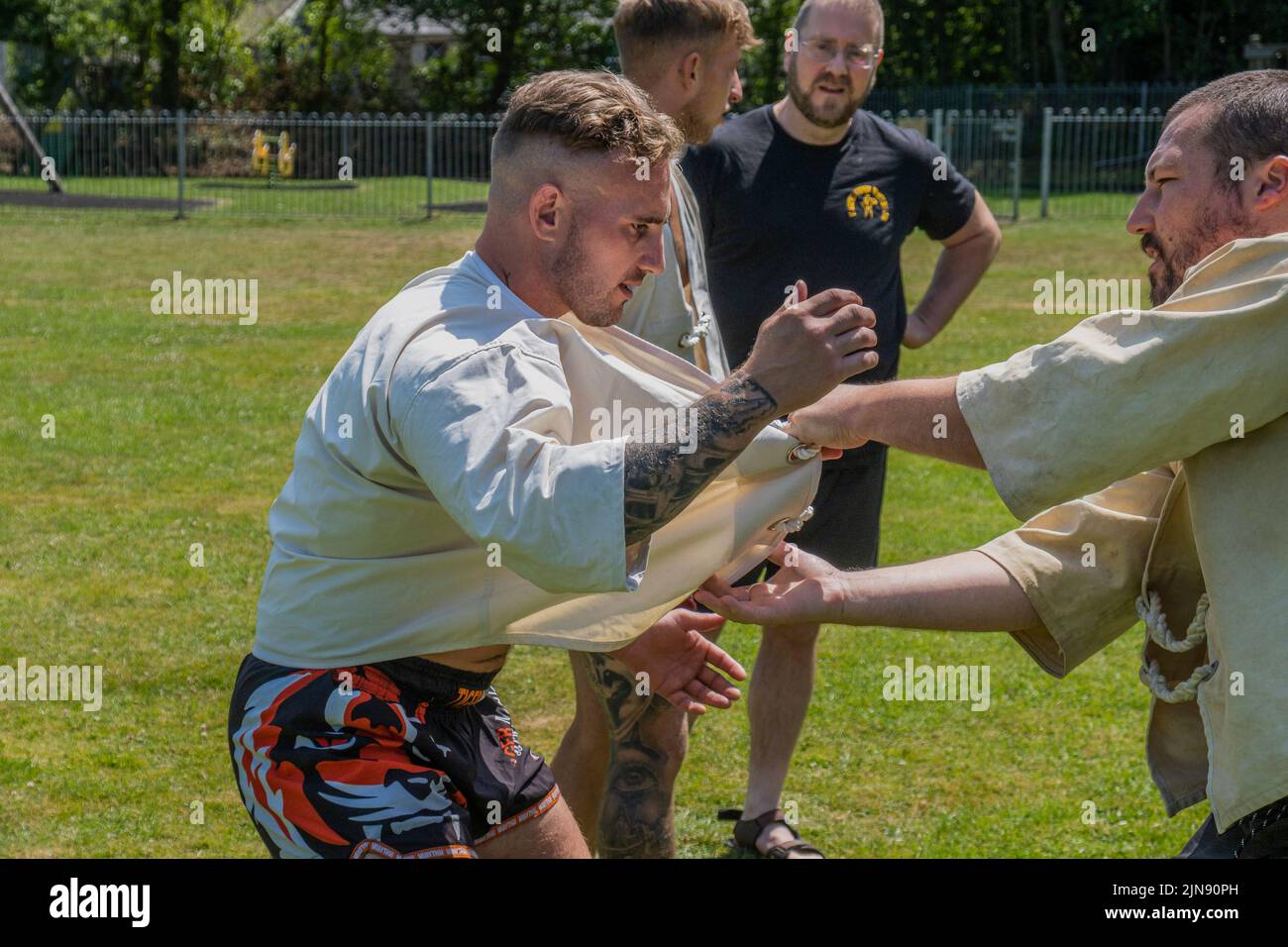 Les entraîneurs enseignent les règles et techniques de la Wrestling cornish avant le début du Grand Tournoi de la Wrestling cornish sur le village pittoresque g Banque D'Images