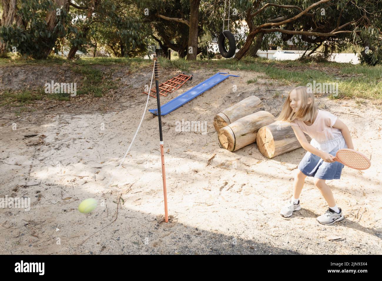 Une australienne jouant au totem tennis dans sa cour avant Banque D'Images