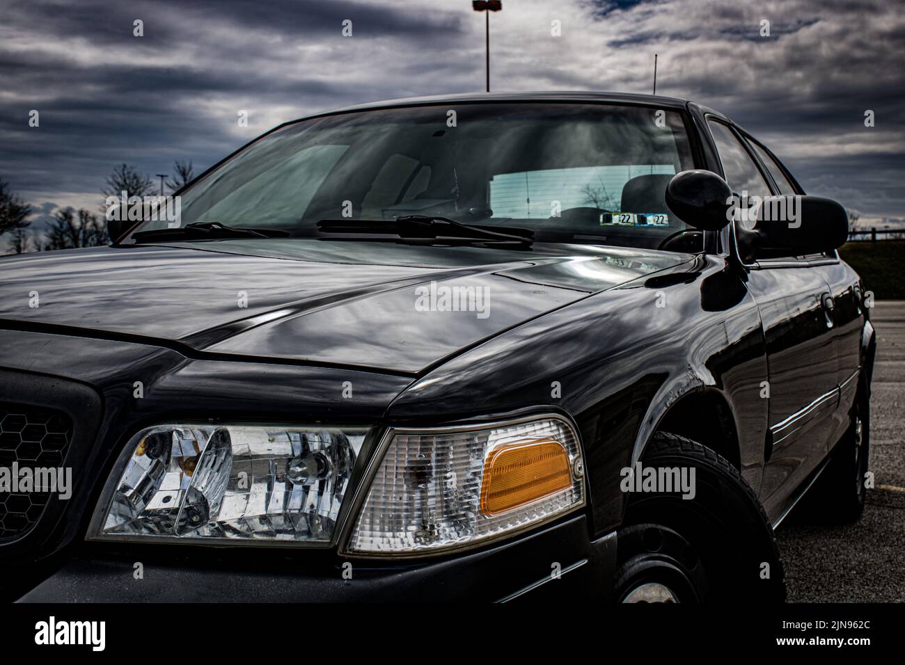 Un Ford Crown Victoria noir et son phare sous les rayons du soleil Banque D'Images
