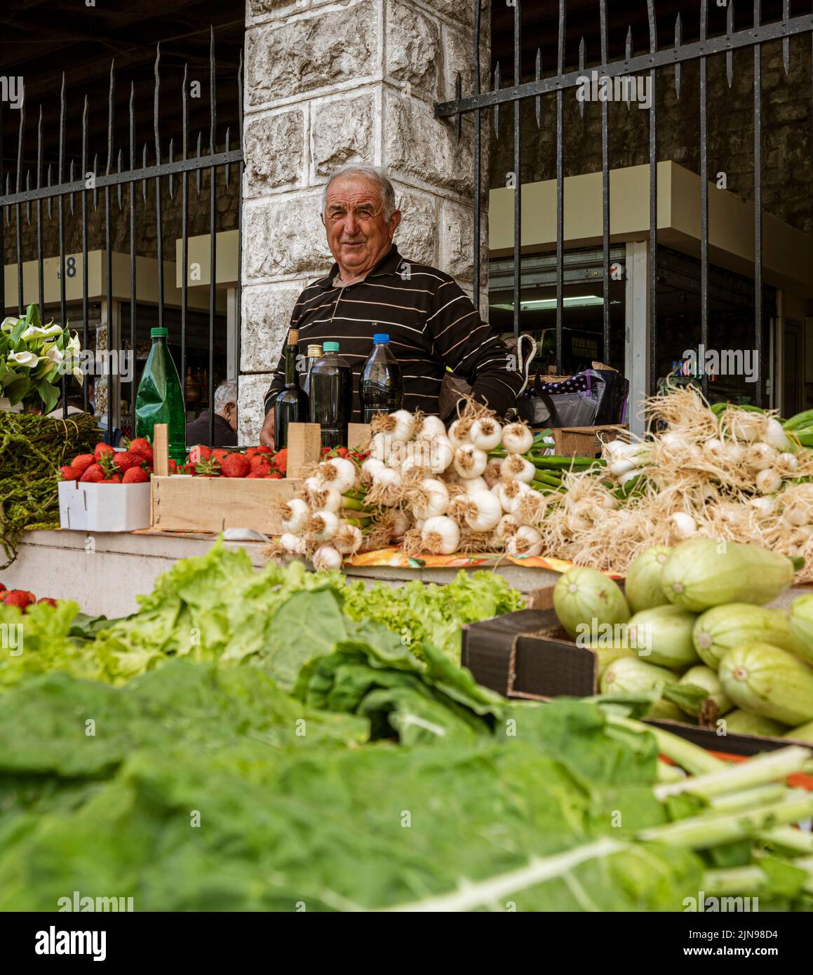 Monténégro - 7 mai 2022 - l'homme vend des fruits et des légumes dans une cabine du marché. Banque D'Images