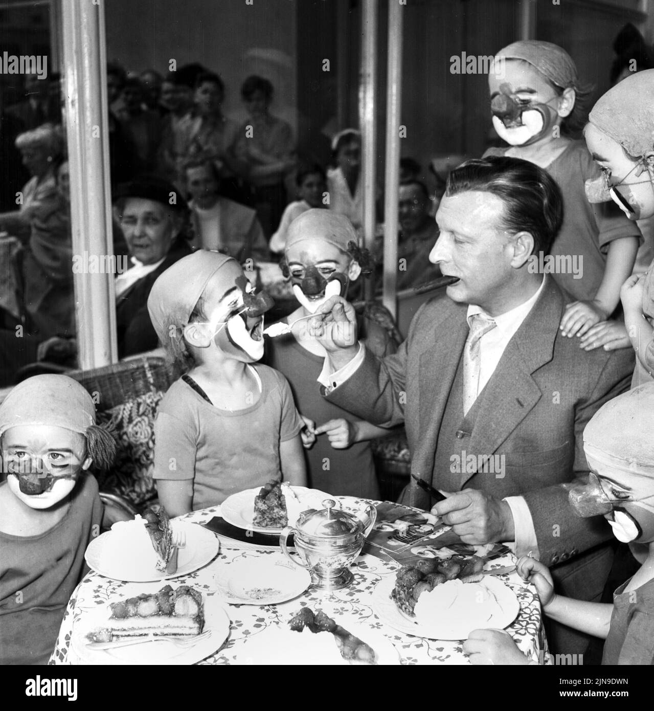 Original-Bildunterschrift: Kuchen mit Sahne für die kleinen Rivels - Am Berliner Kurfürstendamm trank heute der weltberühmte Clown Cahrlie Rvel mit seinen Circus-Kindern BEI 'Kranzler' gemeinsam Kaffee, Berlin, Deutschland 1955, Banque D'Images