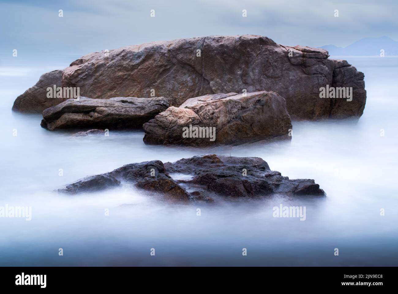 Une mer douce et soyeuse autour des rochers avec une longue exposition. Banque D'Images