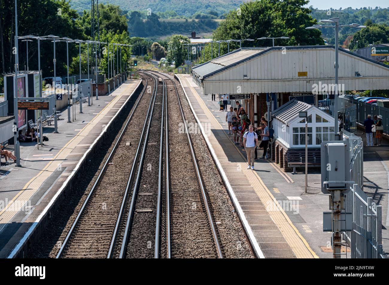 Des personnes attendent sur la plate-forme d'une gare sur la ligne sud-ouest à Petersfield, Hampshire Royaume-Uni. Banque D'Images