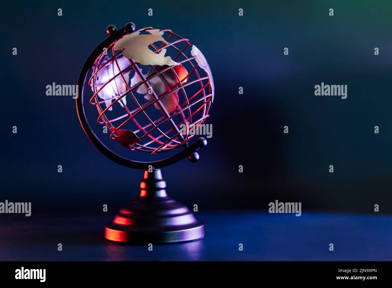 Modèle métallique d'un globe avec carte en bleu et rouge néon. Bipolarité du monde. Concept de géographie. Mise au point sélective, espace de copie Banque D'Images Modèle métallique d'un globe avec carte en bleu et rouge néon. Bipolarité du monde. Concept de géographie. Mise au point sélective, espace de copie Banque D'Images