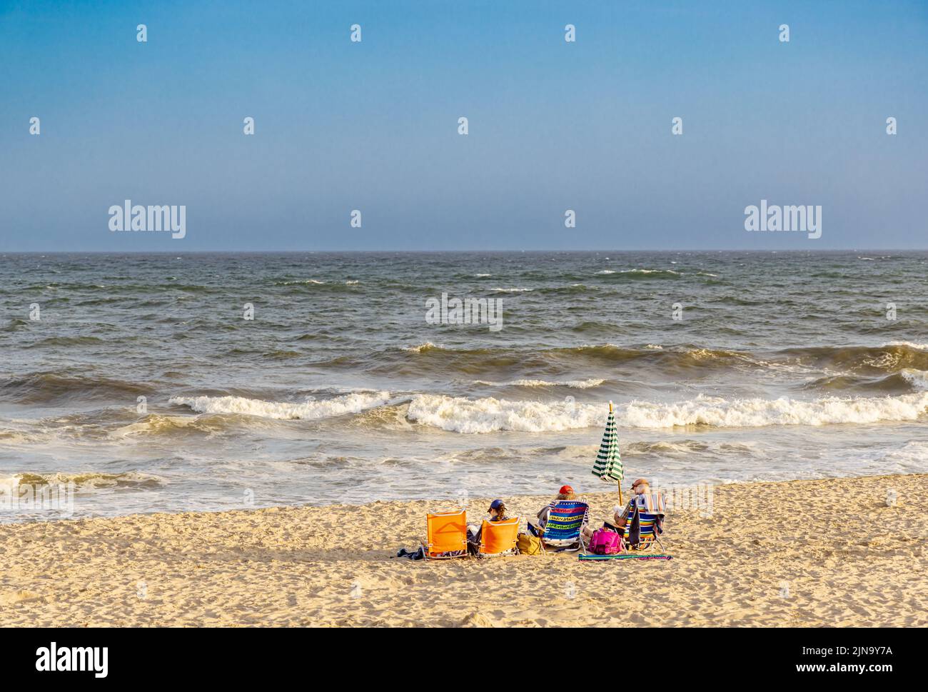 Trois personnes assises sur des chaises de plage à Mecox Beach Banque D'Images