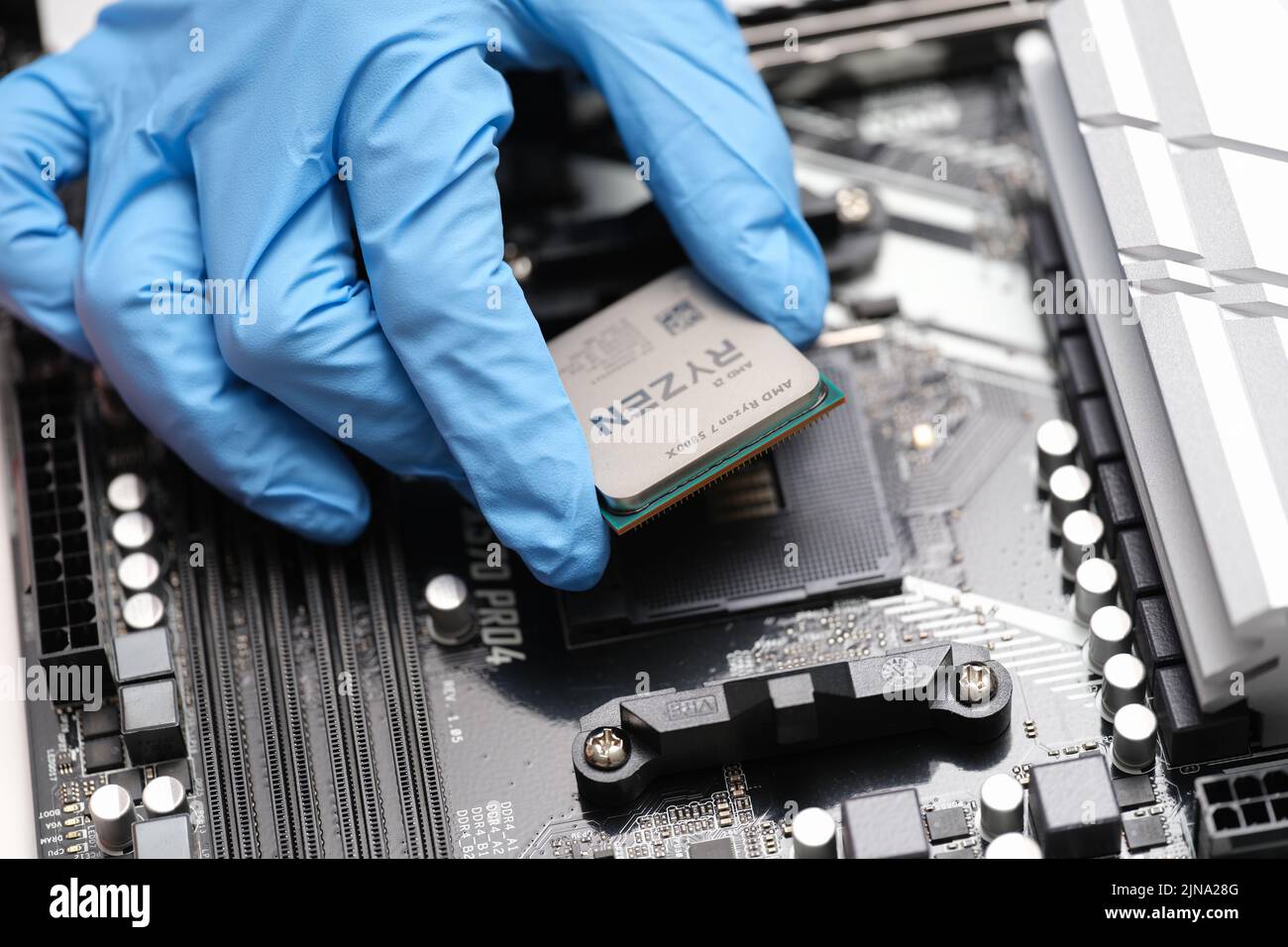 Tbilissi, Géorgie - 26 juillet 2022 : installation du processeur Ryzen de troisième génération sur la carte mère Banque D'Images