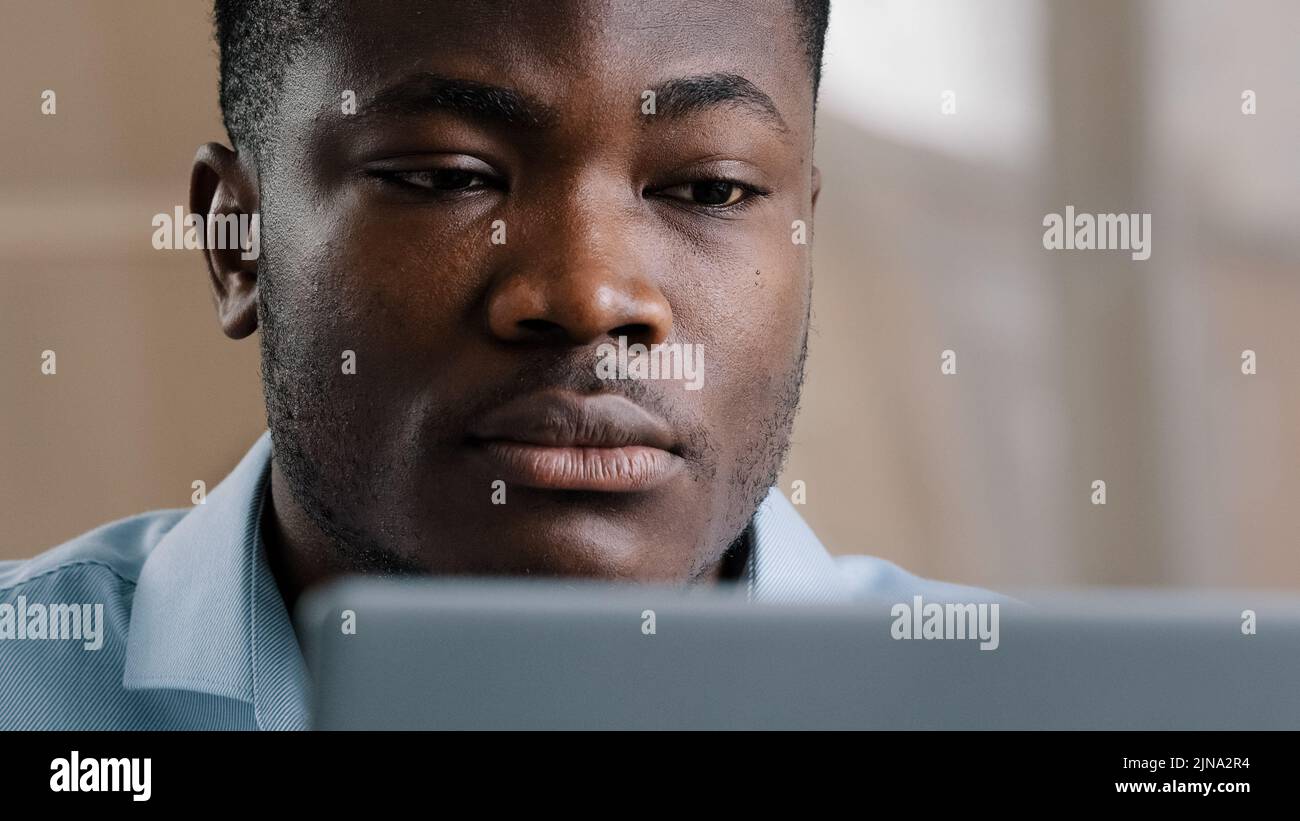 Un jeune homme d'affaires afro-américain sérieux programmeur dactylographiant sur l'ordinateur à la maison de bureau concentré millennium confiant gars utiliser ordinateur portable Banque D'Images