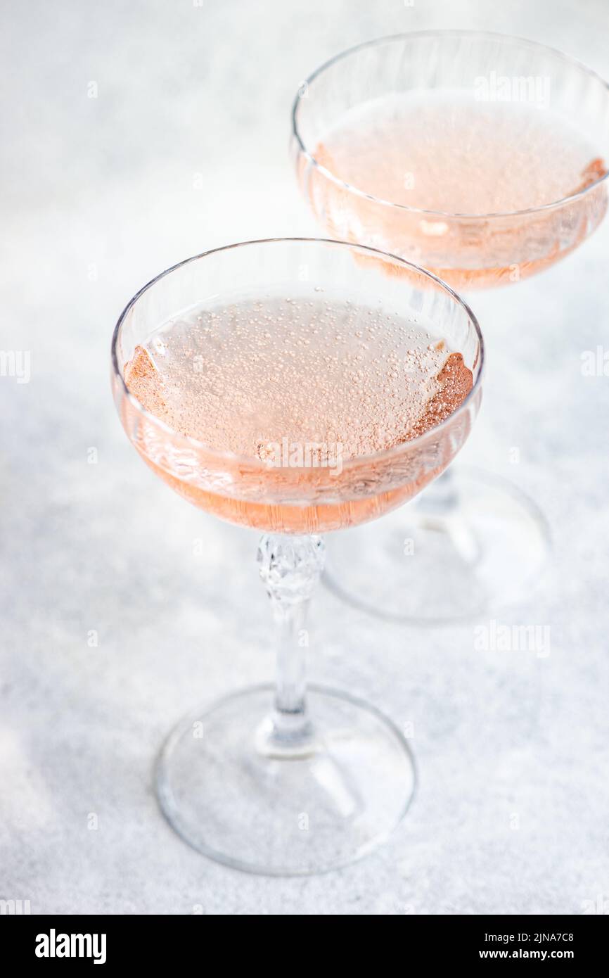 Gros plan de deux verres de champagne rose en coupe à champagne Banque D'Images