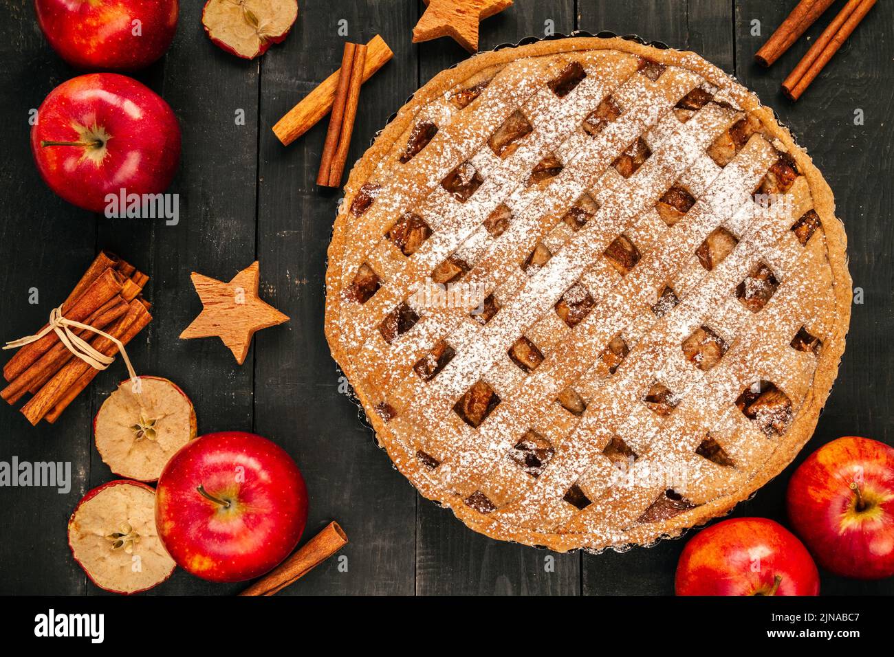 Tarte aux pommes maison avec pommes, noix, bâtons de cannelle et feuilles d'automne. Table en bois pour le dîner de Thanksgiving. Banque D'Images