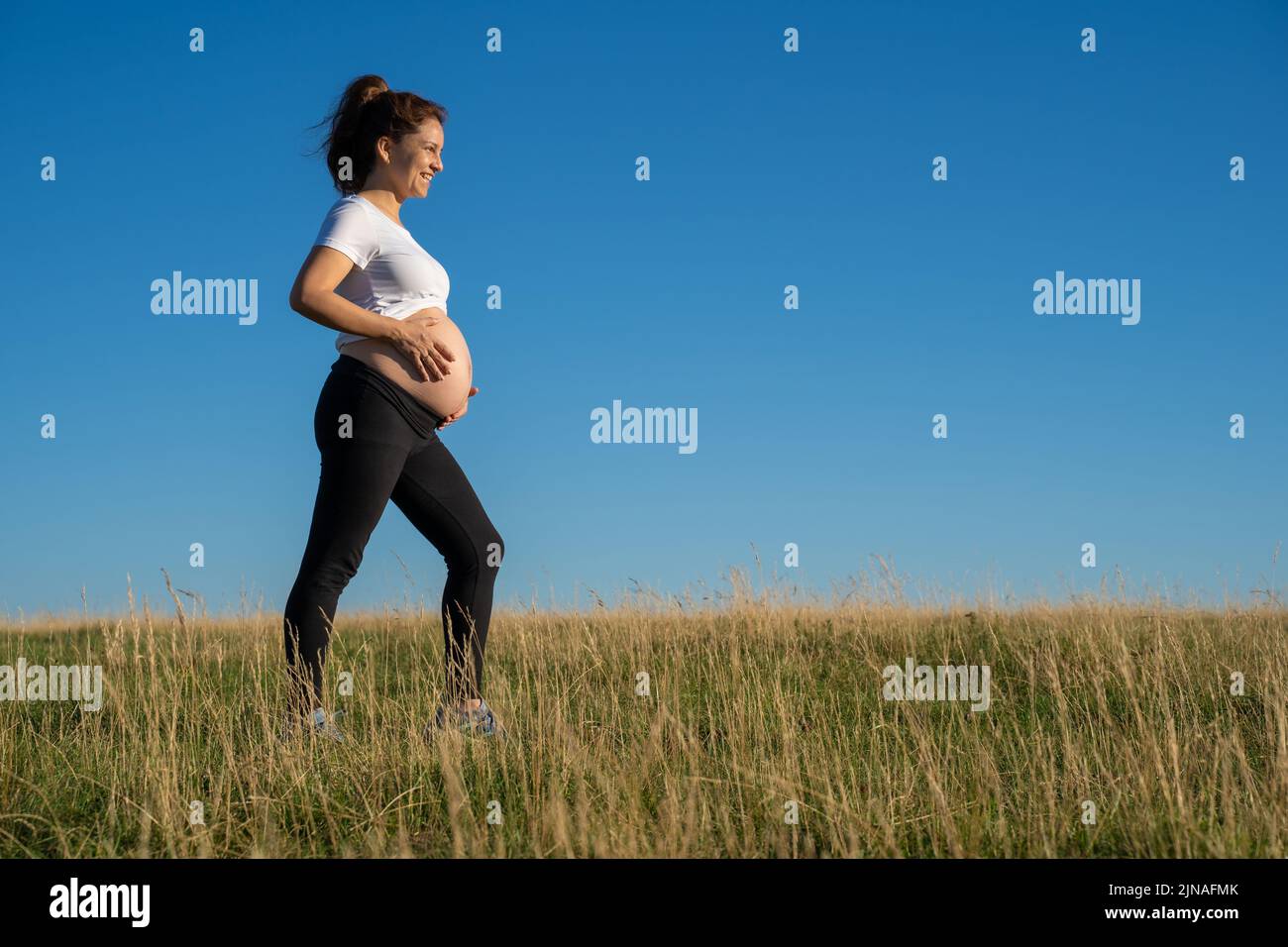 Femme enceinte marchant dans la nature Banque D'Images