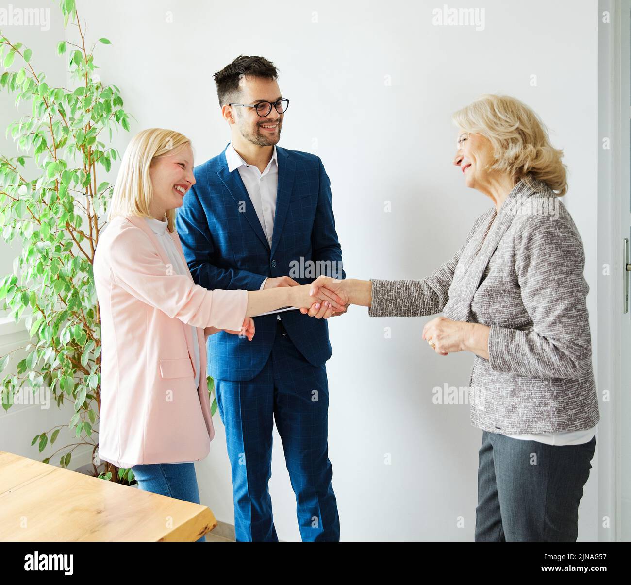 un jeune couple qui tremble les mains traite contrat d'investissement immobilier agent d'accord d'affaires poignée de main signature Banque D'Images
