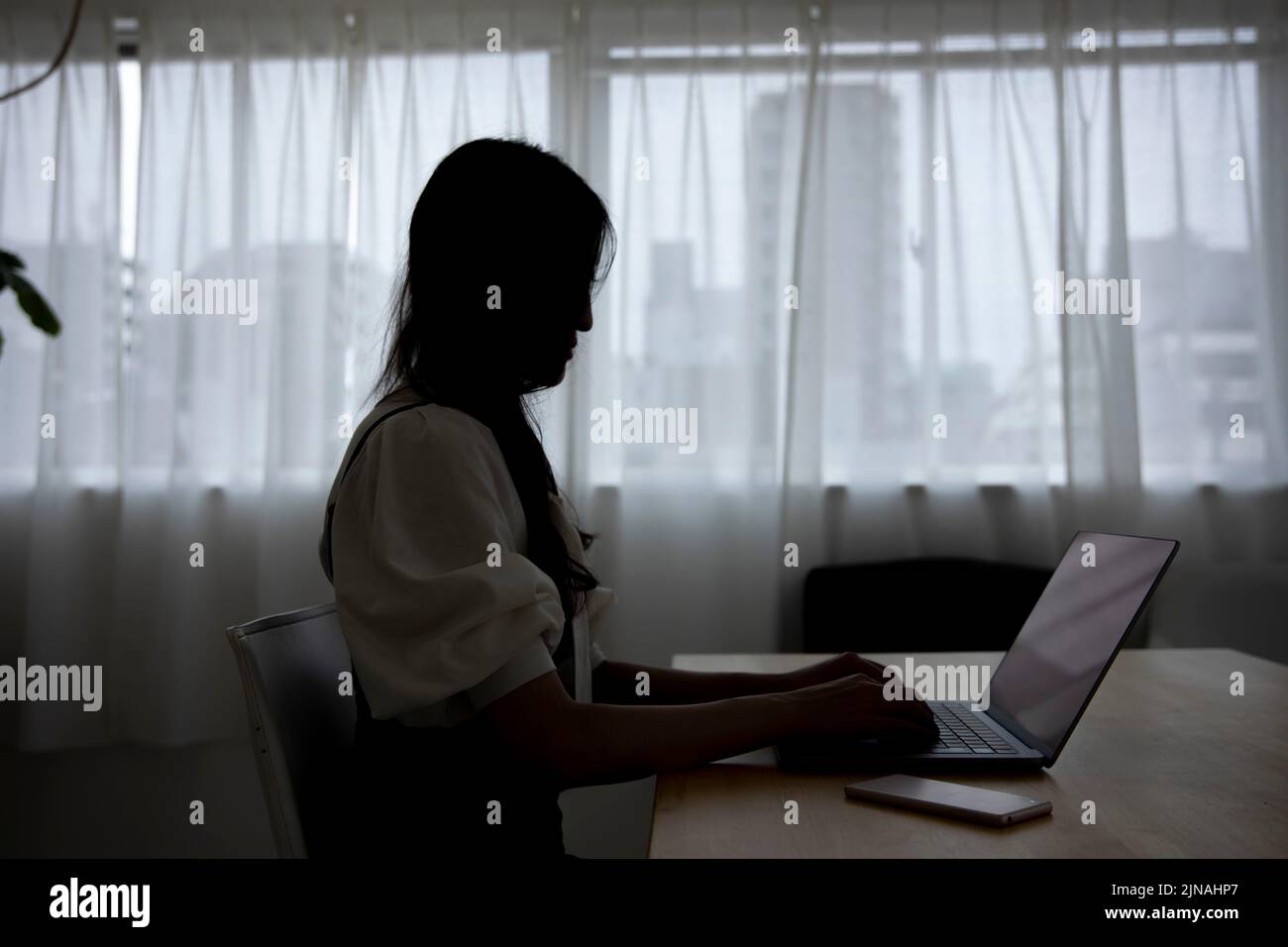 Une femme japonaise qui travaille à distance dans le bureau à domicile Banque D'Images