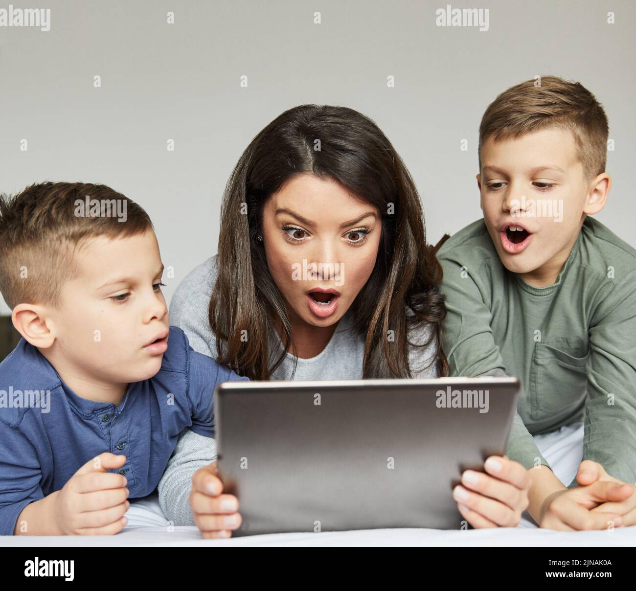 enfant fils mère famille surprise stupéfait de jouer enfant enfant enfant enfant tablette lit technologie ensemble maman parent Banque D'Images