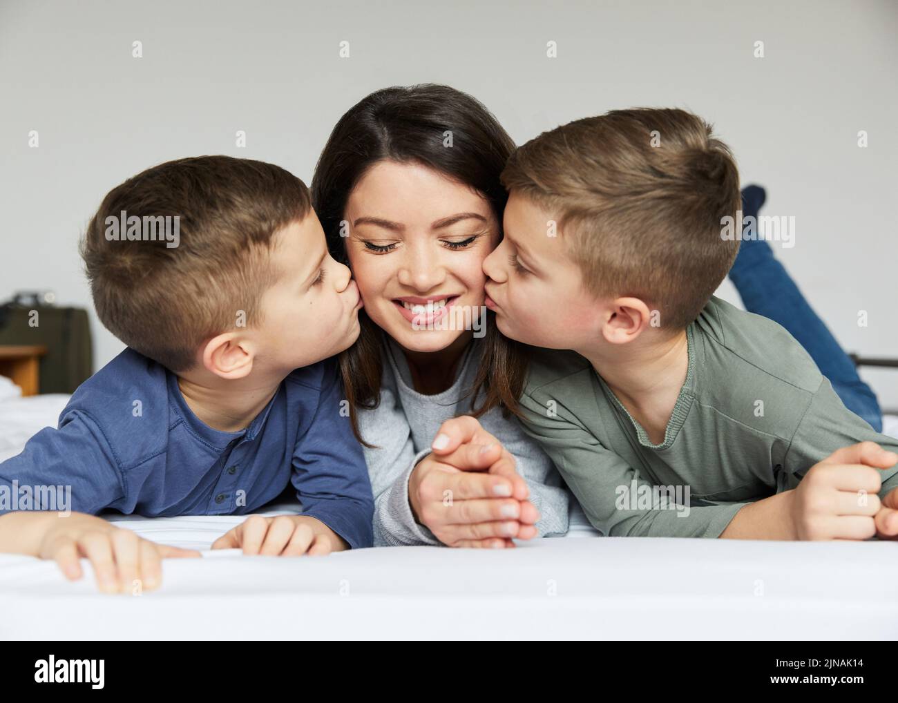 enfant garçon fils mère baiser amour heureux famille soins enfant parent enfant portrait lit chambre Banque D'Images
