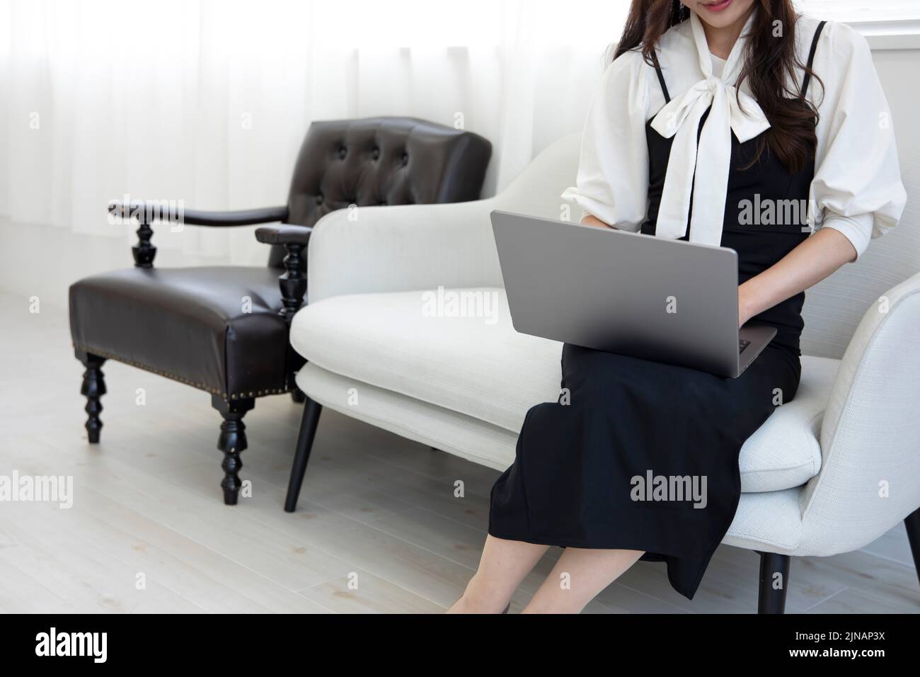 Une japonaise dactylographiant un ordinateur portable par travail à distance dans la composition sans visage de bureau Banque D'Images