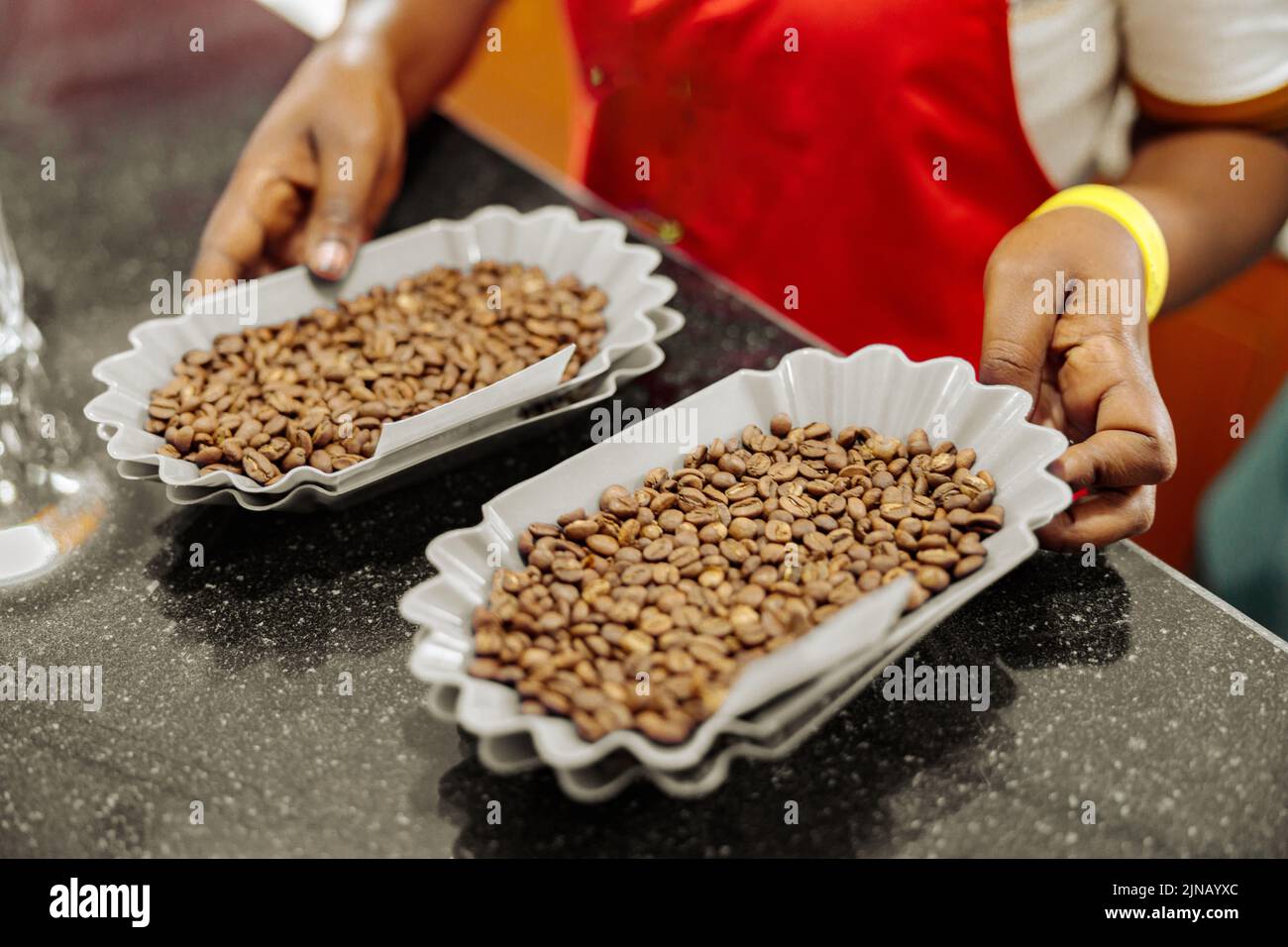 Femme tenant des bols de grains de café pour la dégustation Banque D'Images