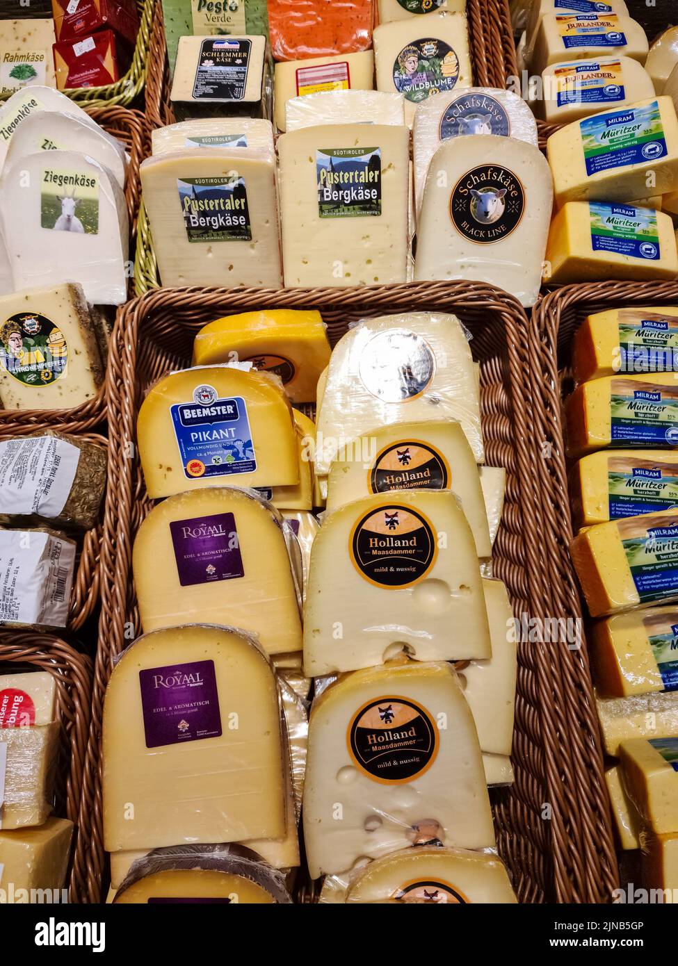 De nombreux types de fromages emballés dans des paniers bruns dans un supermarché allemand Banque D'Images