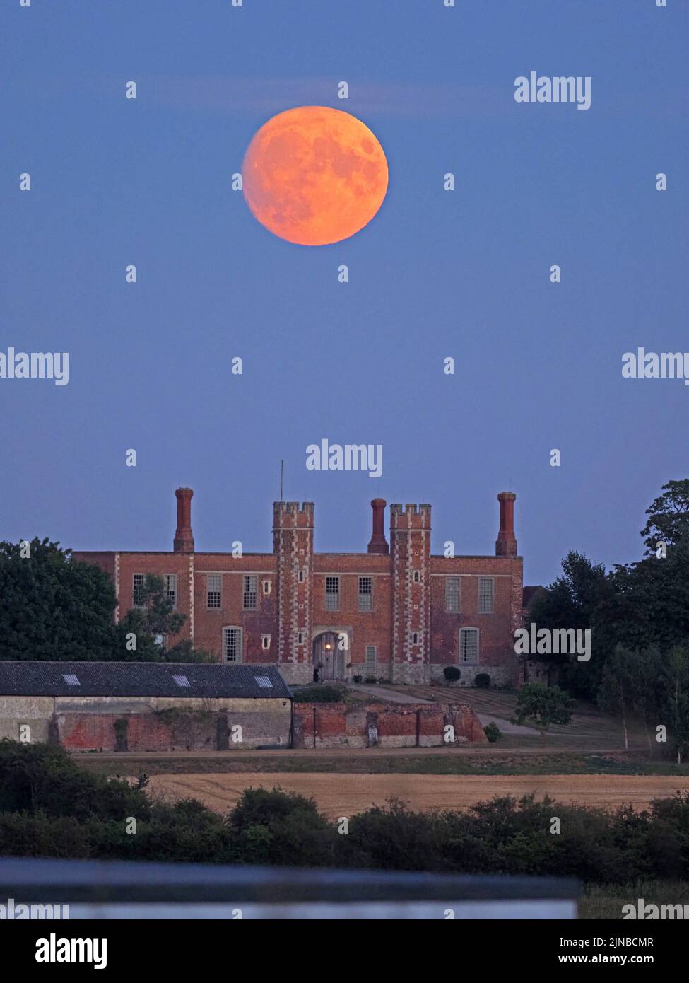 Eastchurch, Kent, Royaume-Uni. 10th août 2022. Météo au Royaume-Uni : la lune d'esturgeon presque complète - la dernière superlune de 2022 - vue s'élevant au-dessus du portail historique Shurland Hall à Eastchurch, Kent. Crédit : James Bell/Alay Live News Banque D'Images