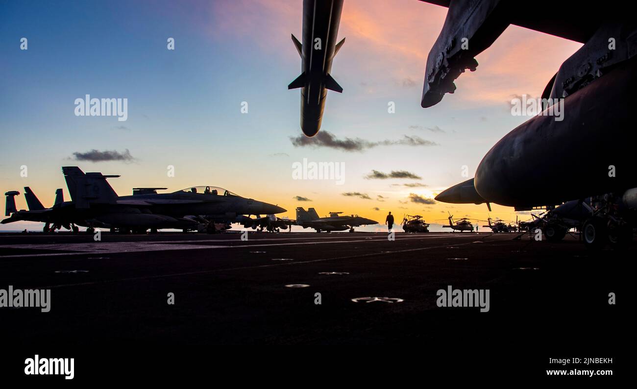 Océan Pacifique, États-Unis. 08th août 2022. Les avions de chasse de la Marine américaine sont silhouettés lorsque le soleil se lève sur le pont de vol du porte-avions de la classe Nimitz USS Ronald Reagan en cours, 8 août 2022 dans la mer des Philippines. Credit: MC3 Oswald Felix Jr./Planetpix/Alay Live News Credit: Planetpix/Alay Live News Banque D'Images