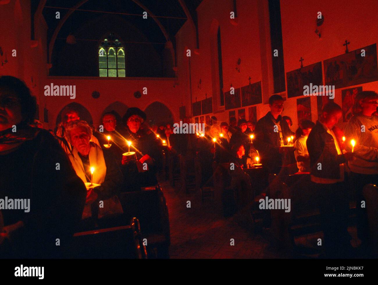 Congrégation tenant une bougie et chantant des hymnes au service de la lumière le samedi Saint Église catholique St Joseph Roehampton Londres Angleterre Banque D'Images