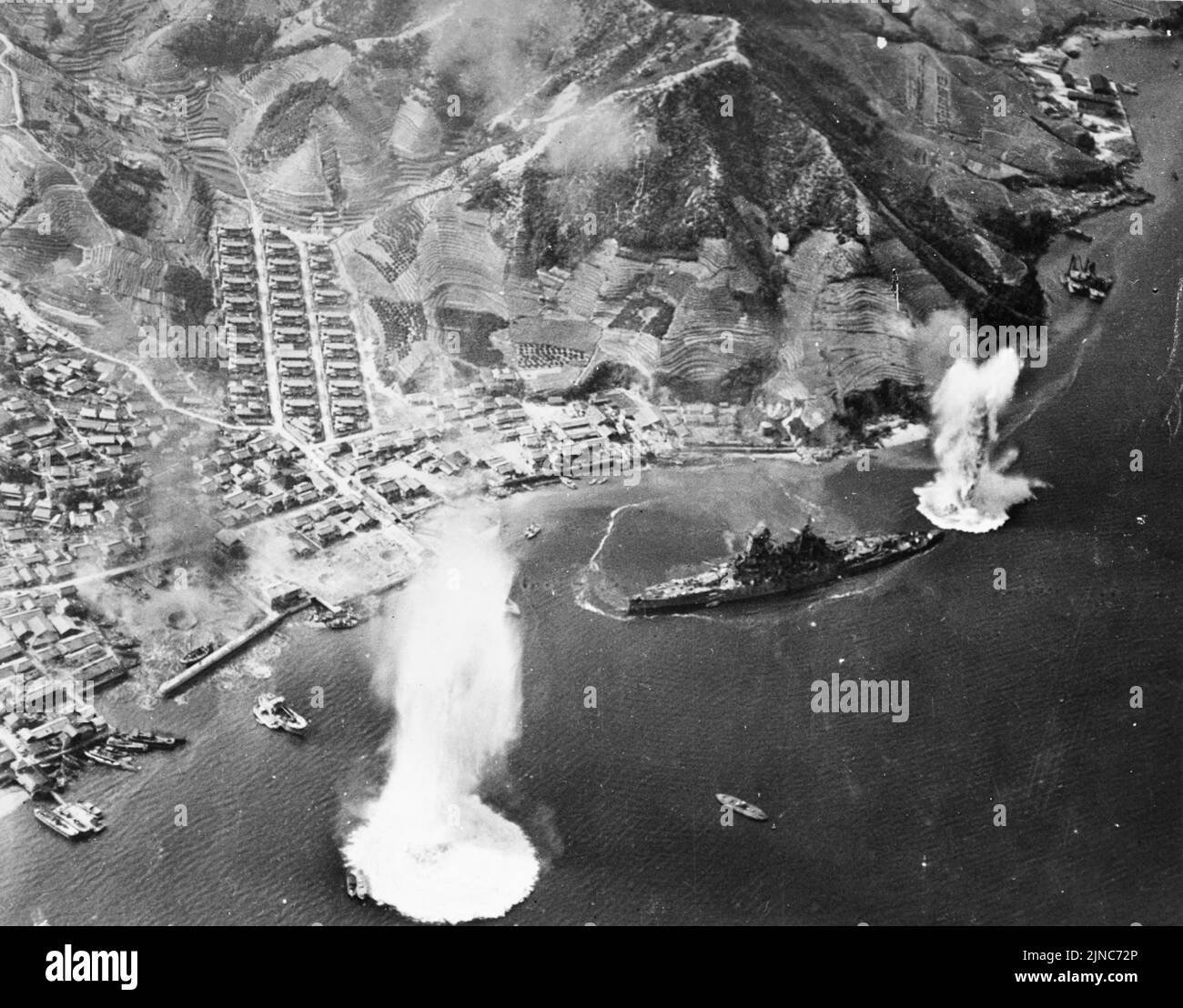 Haruna, cuirassé de la Marine impériale japonaise, à ses amarres près de Kure, au Japon, sous l'attaque d'avions de transport de la Marine américaine, le 28 juillet 1945. Le navire a été frappé et détruit à ses rmoiings pendant cette attaque. Banque D'Images