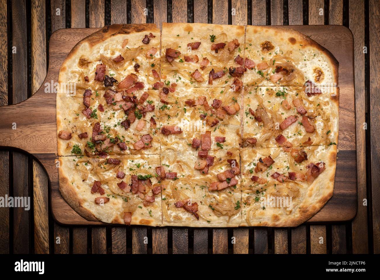 Pizza rectangulaire Flamkuchen tarte flambee avec bacon et poulet sur fond de table en bois Banque D'Images