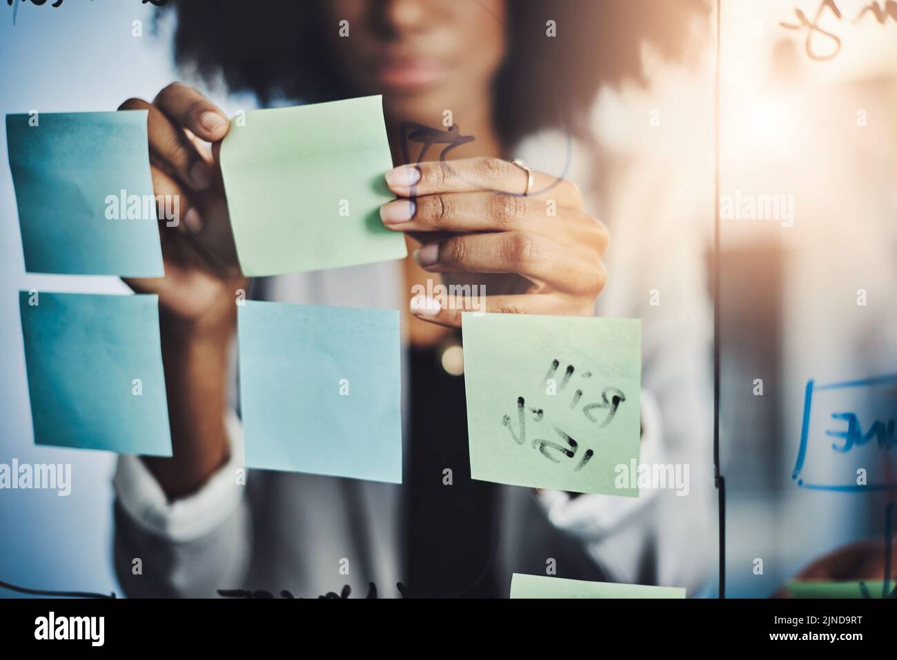 Planifiez des choses importantes. Gros plan d'une femme d'affaires remue-méninges sur un mur de verre dans un bureau. Banque D'Images