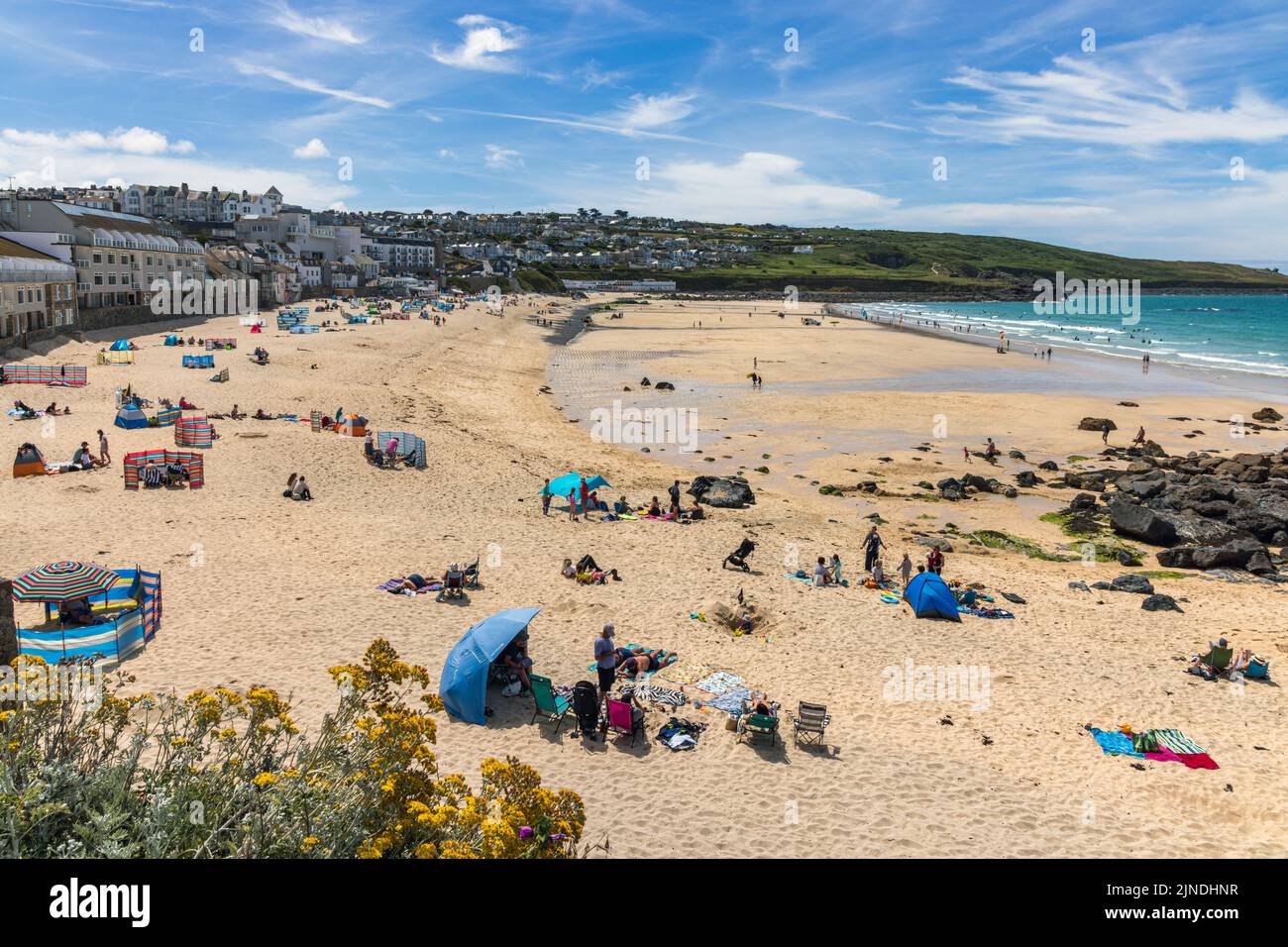 Les gens qui profitent d'une journée ensoleillée d'été à la plage de Porthmeor à St Ives, en Cornouailles, en Angleterre. Banque D'Images