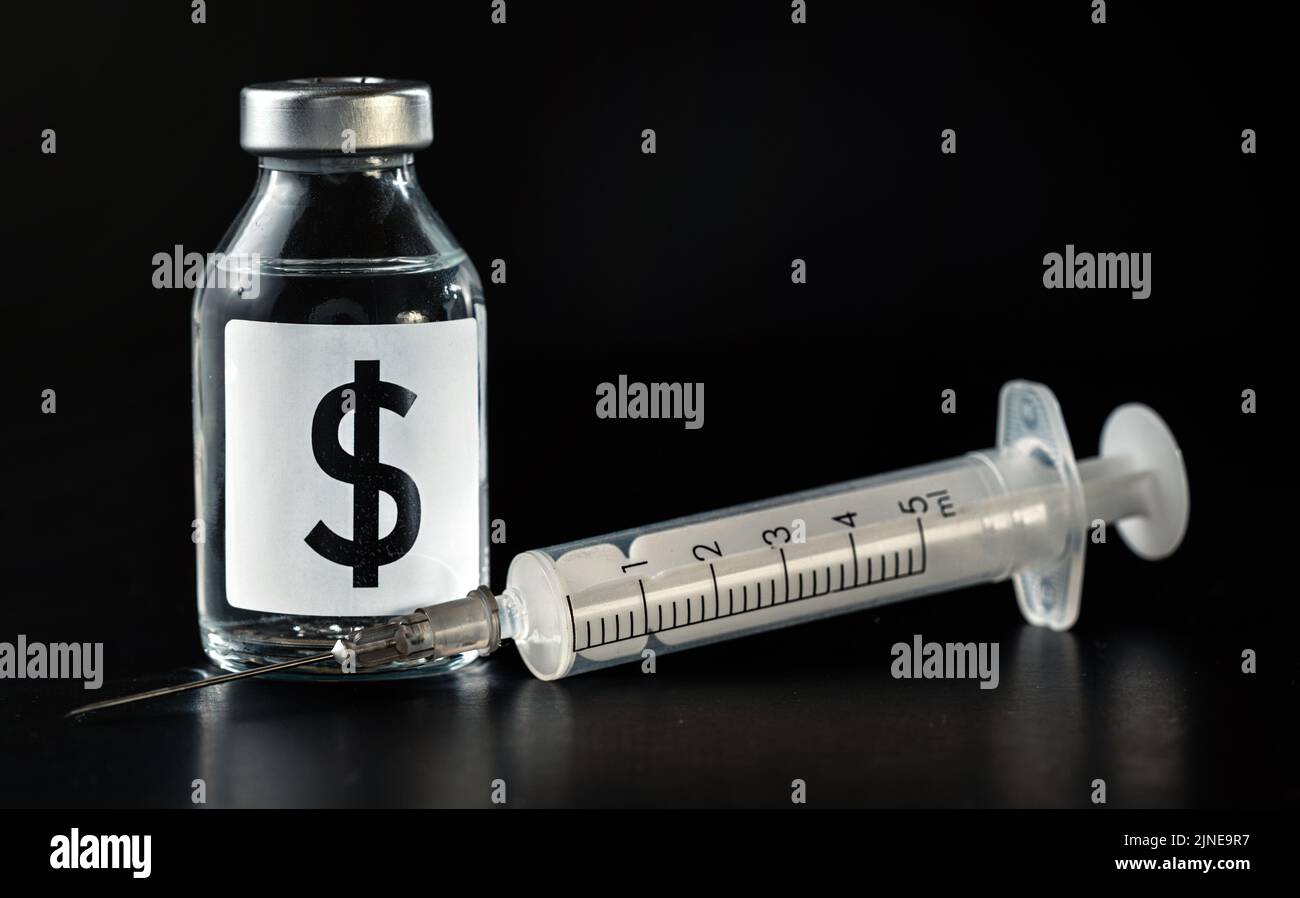 Dollar signe de monnaie sur la bouteille de vaccin, seringue hypodermique avec aiguille près - coût ou le concept d'injection de capital. Fond noir Banque D'Images