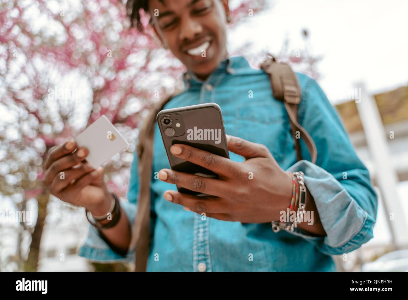 Guy tenant la carte regardant joyeusement l'écran de smartphone Banque D'Images