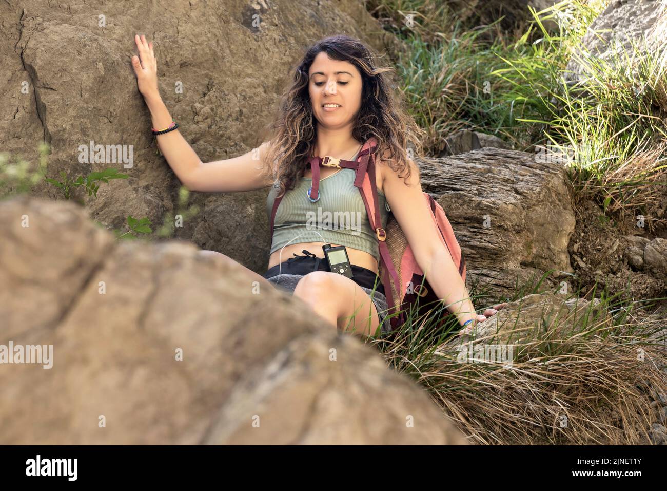 brunette femme descendant quelques rochers dans les montagnes Banque D'Images
