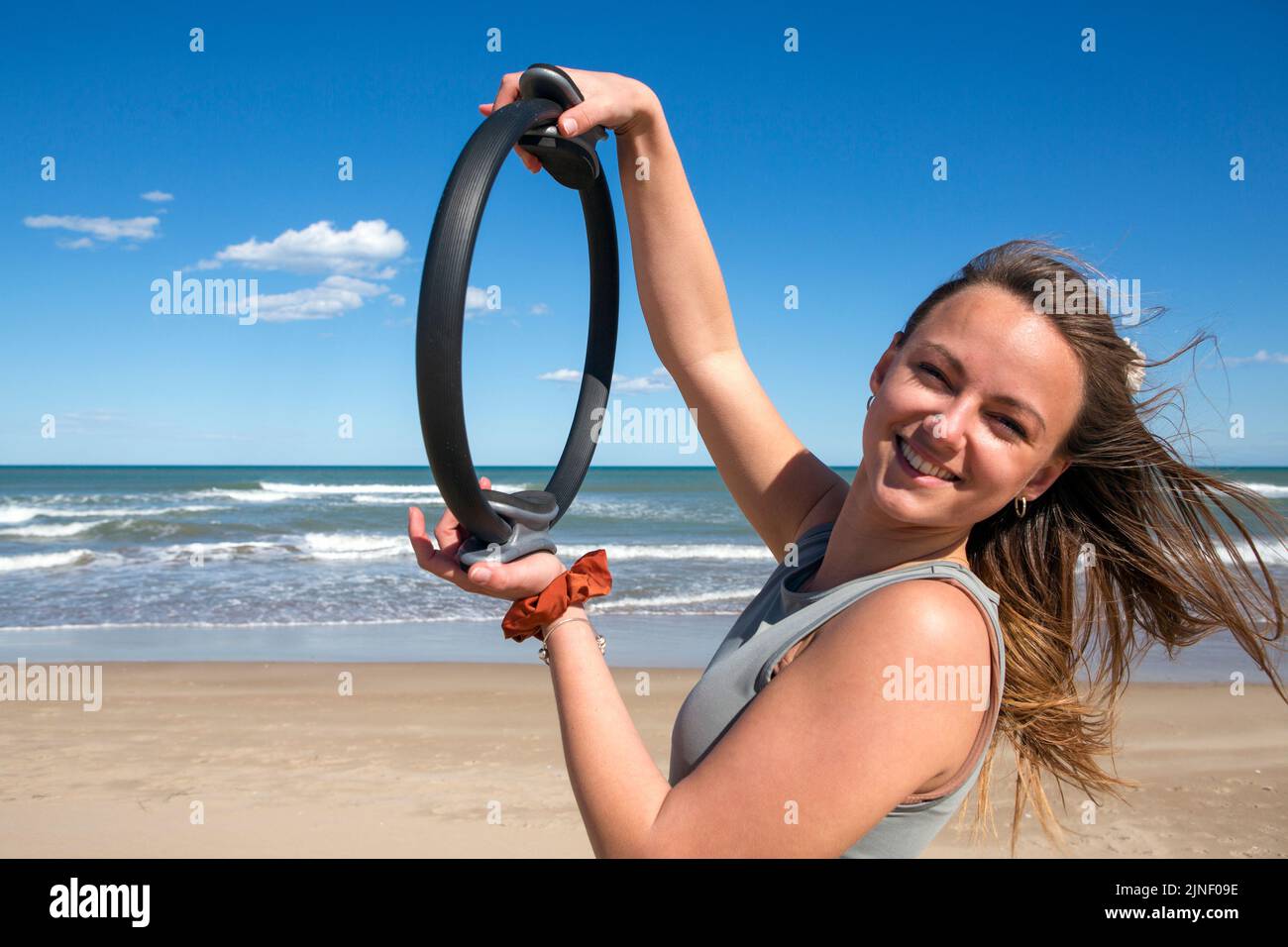 femme avec pilates anneau sur la plage Banque D'Images