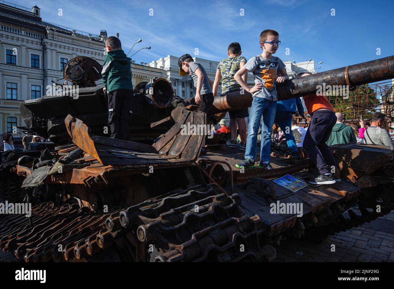 Des enfants jouent sur un char russe détruit lors d'une exposition montrant du matériel militaire russe détruit lors de l'invasion de l'Ukraine par la Russie dans le centre de Kiev. En 24 février 2022, les troupes russes sont entrées en territoire ukrainien, ce qui a provoqué un conflit qui a provoqué la destruction et une crise humanitaire. Banque D'Images