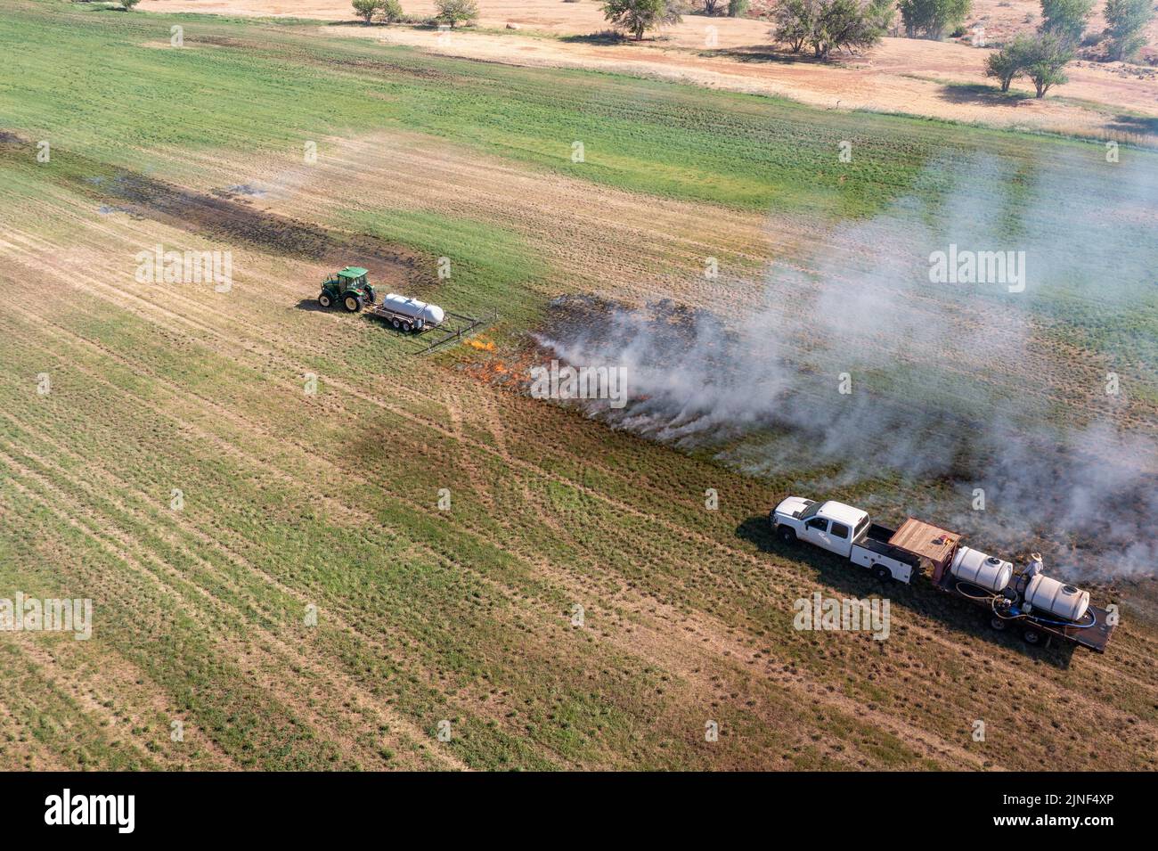 Un tracteur tire un brûleur au propane pour brûler les mauvaises herbes — free download