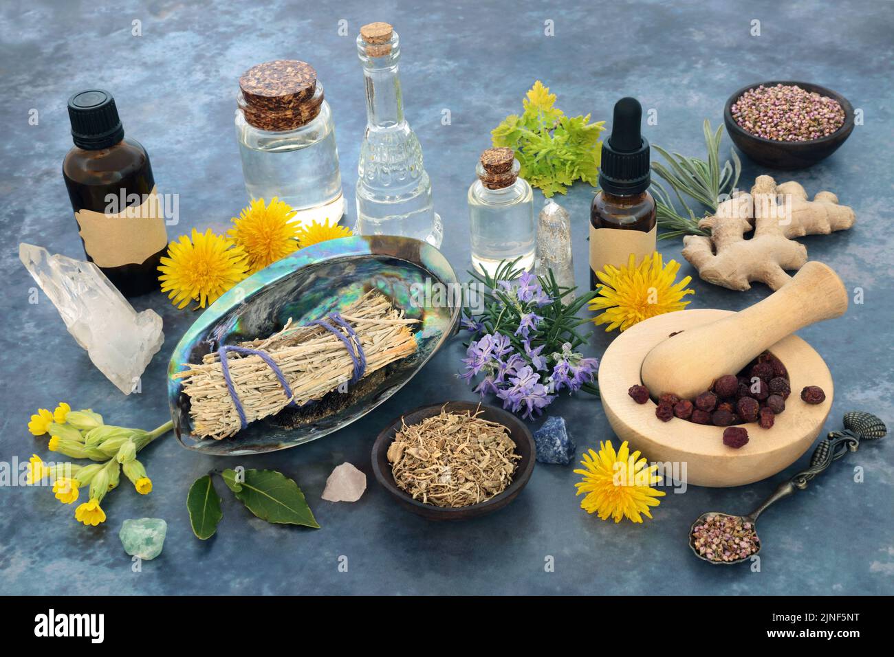 Ingrédients rituels de nettoyage avec bâton de sauge, cristaux, huiles essentielles, herbes et fleurs. Guérison païenne et amérindienne chamanique. Banque D'Images